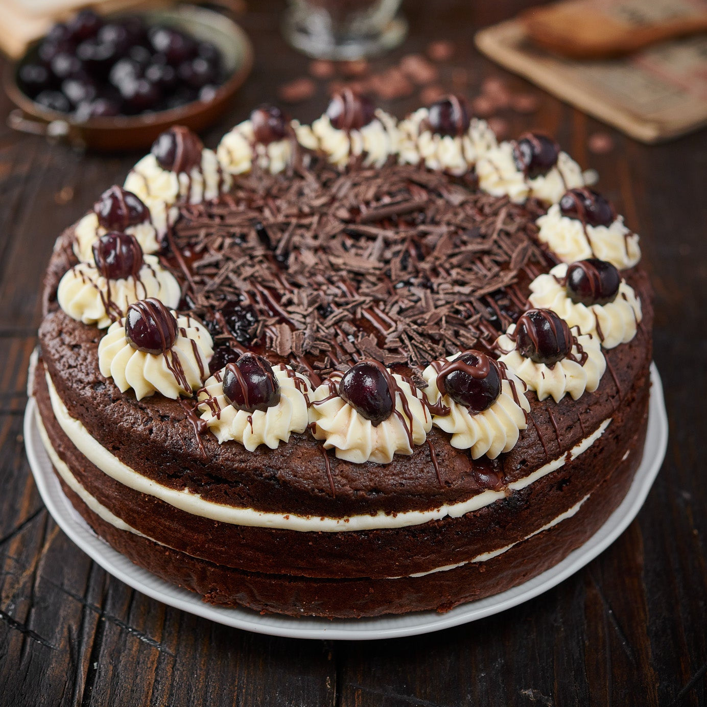 black forest cake with vanilla frosting and cherries